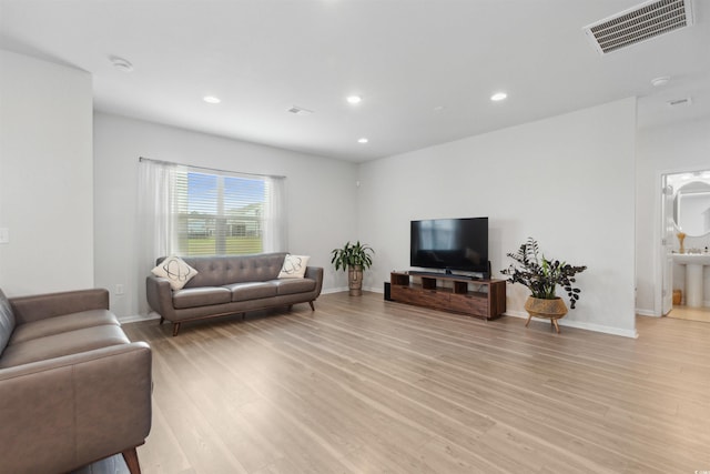 living room featuring baseboards, recessed lighting, light wood-style flooring, and visible vents