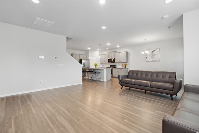 living area featuring recessed lighting, a chandelier, light wood-style flooring, and visible vents