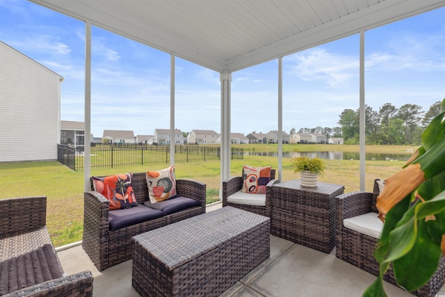 sunroom with an outdoor living space, a water view, and a residential view