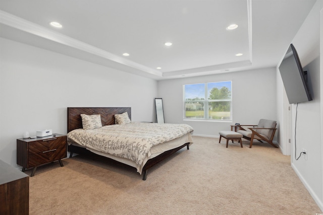 bedroom featuring recessed lighting, baseboards, a tray ceiling, and light carpet
