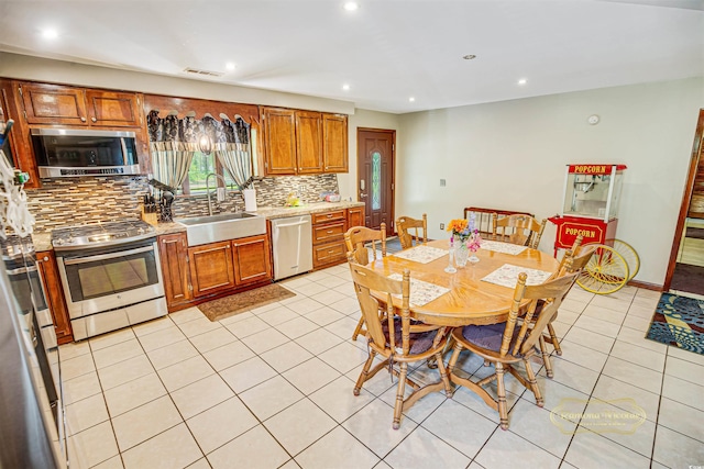 4391 Party Pines Rd, Conway, SC 29526 - kitchen with a sink, brown cabinets, light tile patterned flooring, backsplash, and appliances with stainless steel finishes