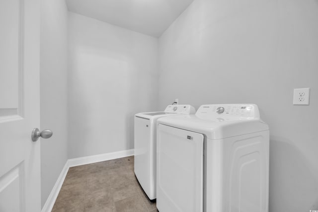 clothes washing area with separate washer and dryer, baseboards, and laundry area