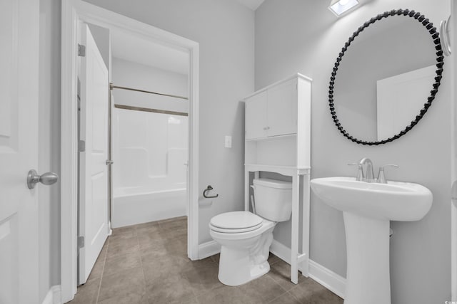 full bath featuring a sink, tile patterned floors, baseboards, toilet, and bathing tub / shower combination