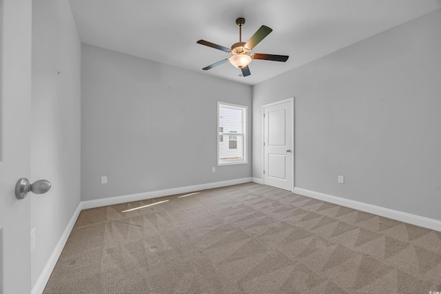 spare room featuring baseboards, a ceiling fan, and carpet flooring