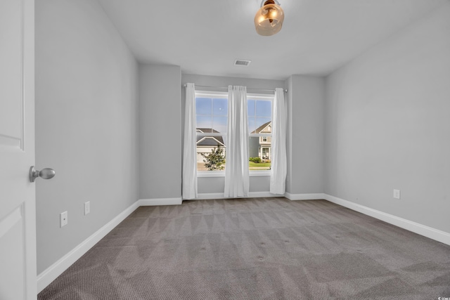 carpeted empty room with visible vents and baseboards