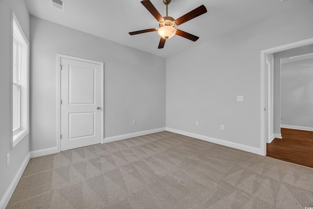 interior space with baseboards, carpet, a ceiling fan, and visible vents