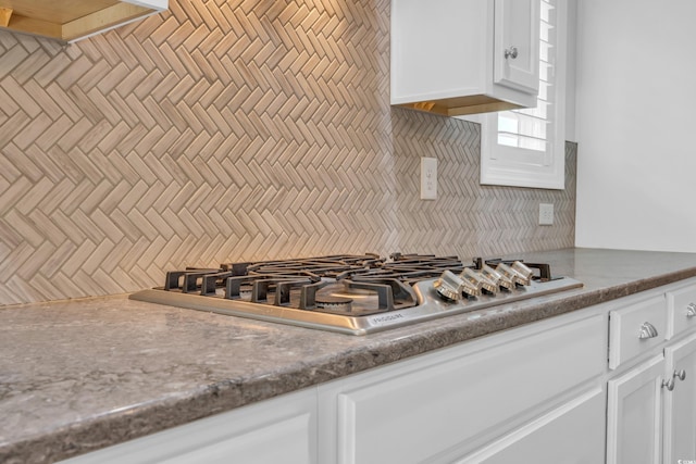 kitchen with white cabinetry, tasteful backsplash, and stainless steel gas stovetop