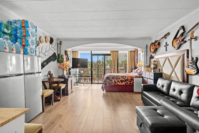 bedroom featuring arched walkways, ornamental molding, and access to outside