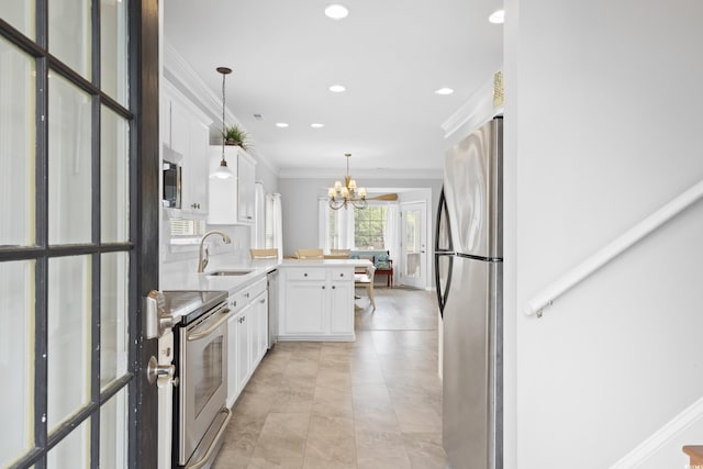 kitchen with appliances with stainless steel finishes, a sink, a peninsula, crown molding, and white cabinets