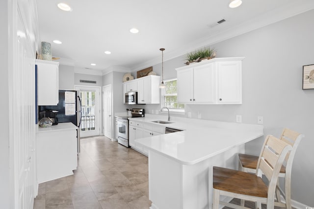 kitchen with stainless steel appliances, a sink, plenty of natural light, light countertops, and recessed lighting