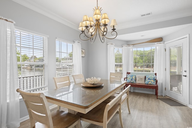 dining room with light wood-type flooring, a chandelier, plenty of natural light, ornamental molding, and baseboards