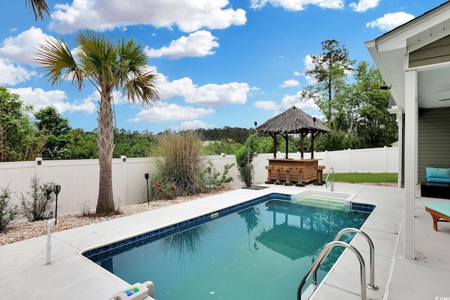 view of pool with a patio, a fenced in pool, a fenced backyard, outdoor dry bar, and a gazebo