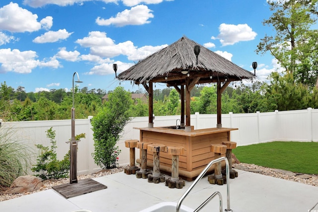view of patio / terrace with outdoor dry bar, a gazebo, and a fenced backyard