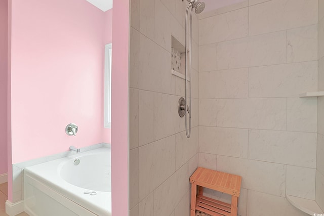 full bath with a garden tub and a tile shower