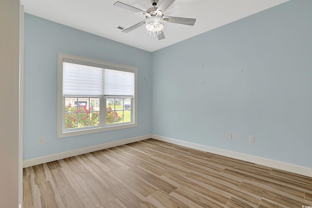 unfurnished room with baseboards, ceiling fan, and light wood-style flooring