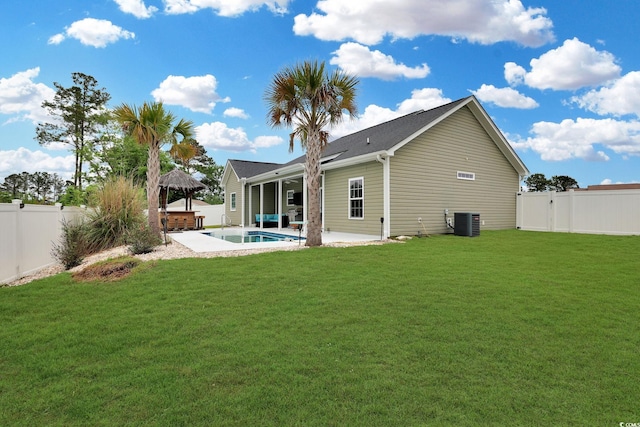 back of house with a gazebo, a fenced backyard, central AC unit, and a yard