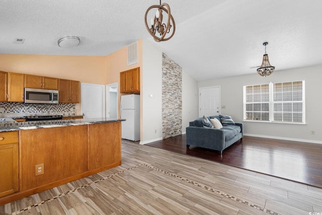 408 Chesterfield Ct, Myrtle Beach, SC 29577 - kitchen featuring stainless steel appliances, a chandelier, brown cabinets, open floor plan, and pendant lighting