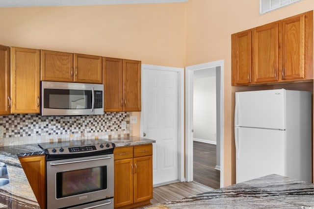 408 Chesterfield Ct, Myrtle Beach, SC 29577 - kitchen featuring stainless steel appliances, tasteful backsplash, dark stone counters, and brown cabinetry