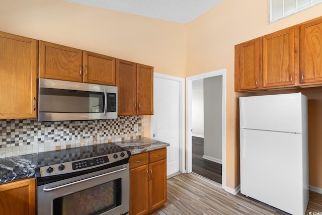 408 Chesterfield Ct, Myrtle Beach, SC 29577 - kitchen featuring stainless steel appliances, light wood-style floors, tasteful backsplash, and brown cabinets