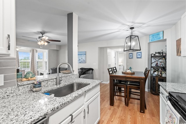 2262 Andover Dr Unit E, Surfside Beach, SC 29575 - kitchen with a sink, light wood-style floors, white cabinetry, and light stone counters