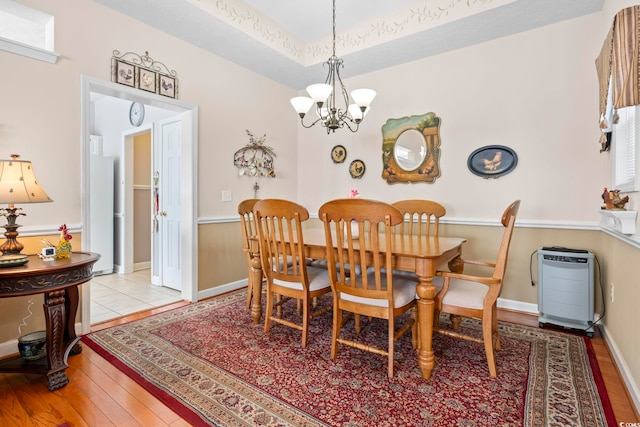 dining room featuring baseboards, a notable chandelier, and hardwood / wood-style floors