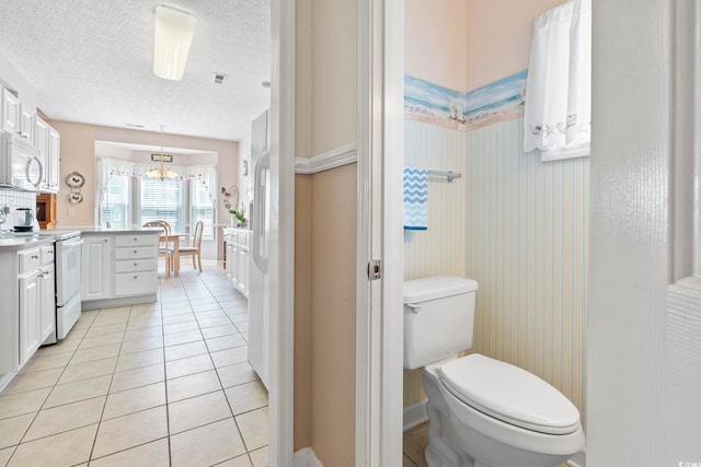 full bath featuring toilet, tile patterned floors, a textured ceiling, and vanity