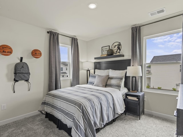 carpeted bedroom featuring recessed lighting, baseboards, visible vents, and multiple windows