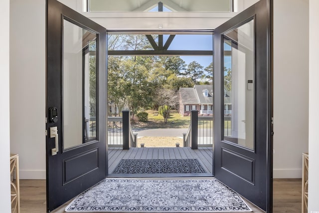 entryway with baseboards, a wealth of natural light, and wood finished floors