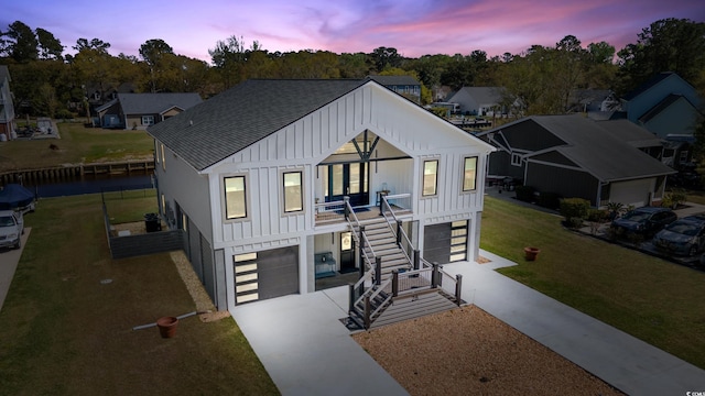 view of front facade featuring board and batten siding, stairway, driveway, and a garage