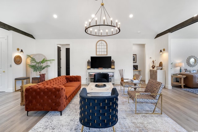 living area with baseboards, a fireplace, wood finished floors, and a chandelier