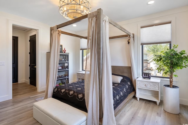 bedroom featuring baseboards, recessed lighting, wood finished floors, and a chandelier