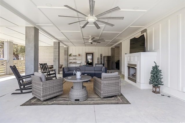 living room with a ceiling fan and exterior fireplace