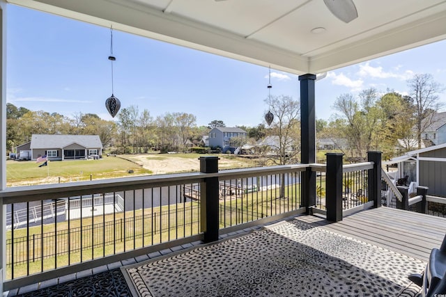 deck with a residential view and a ceiling fan