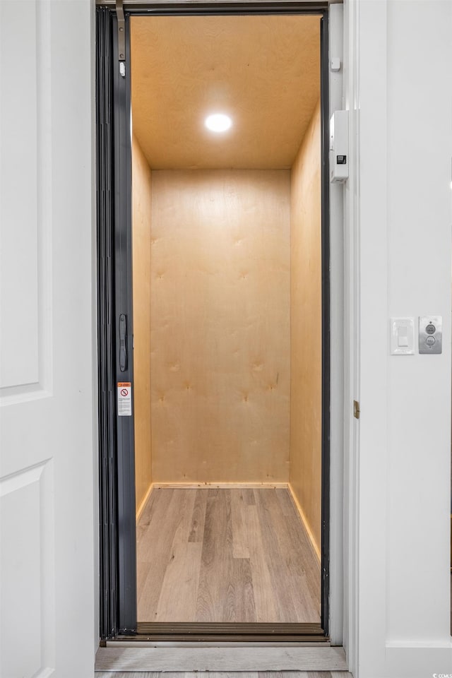 interior details with wood finished floors and elevator
