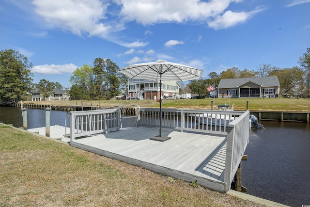 dock area with a lawn and a deck with water view