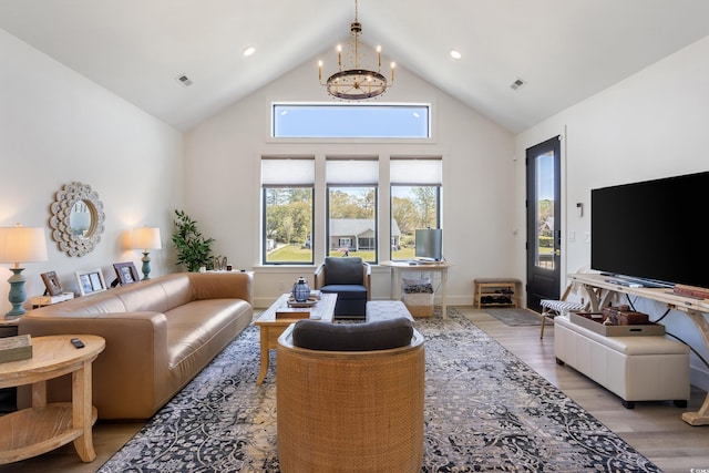 living area featuring visible vents, a chandelier, high vaulted ceiling, and a healthy amount of sunlight