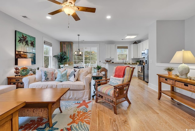 living area featuring a ceiling fan, recessed lighting, light wood finished floors, and visible vents