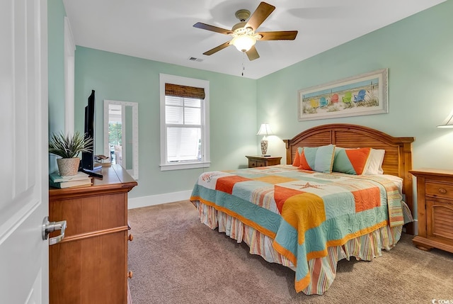 carpeted bedroom with visible vents, a ceiling fan, and baseboards