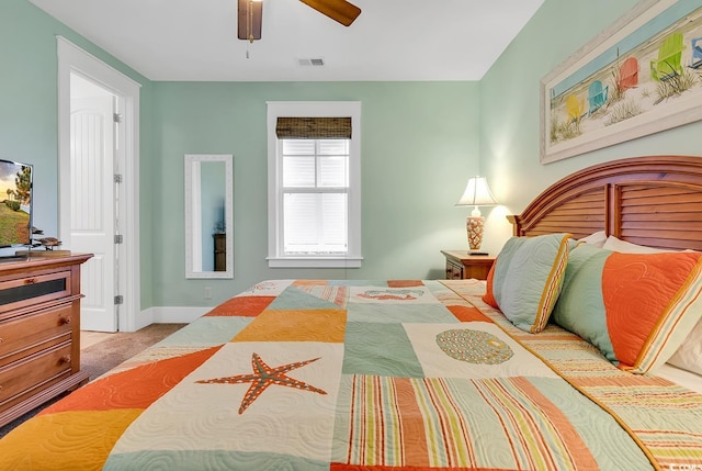 carpeted bedroom with visible vents, a ceiling fan, and baseboards
