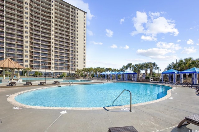 pool with a patio and a gazebo