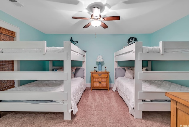 carpeted bedroom with a ceiling fan and visible vents