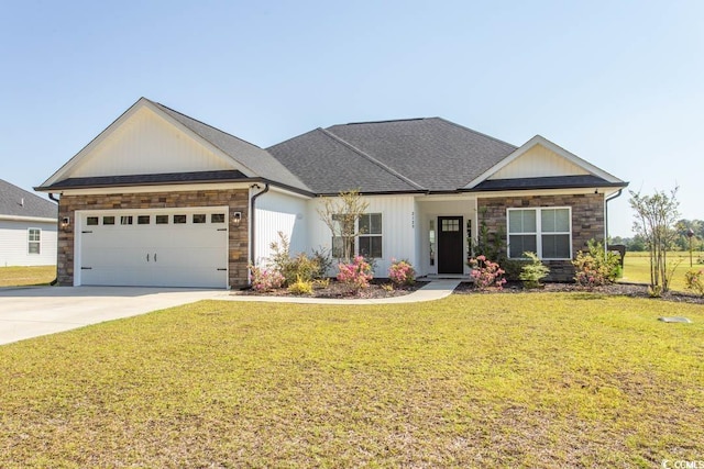 view of front facade featuring a front yard, driveway, stone siding, and a garage