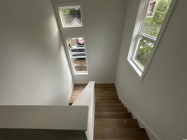 stairway featuring baseboards and wood finished floors