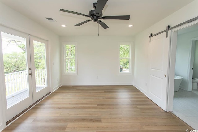 2212 Dykman Cir, Little River, SC 29566 - empty room with a barn door, a ceiling fan, light wood-type flooring, recessed lighting, and baseboards