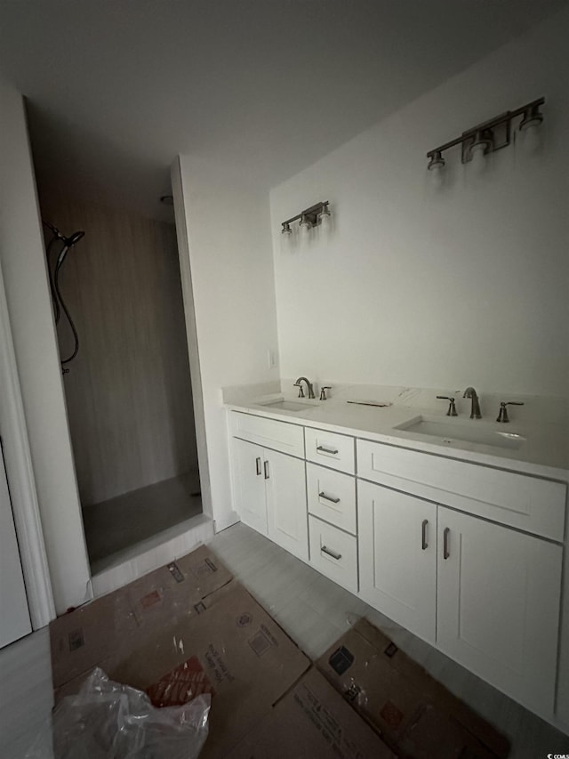 bathroom with double vanity, a sink, and a stall shower