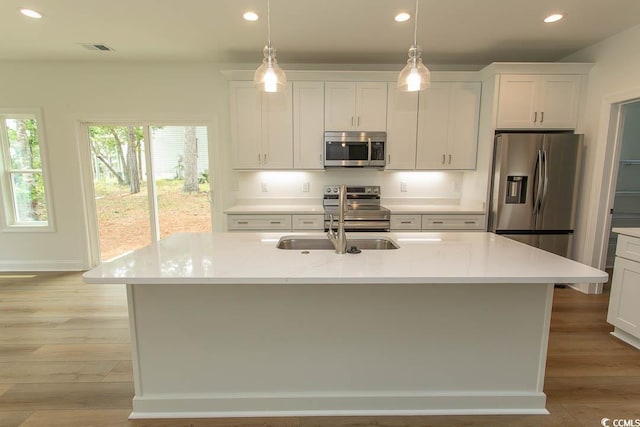 2212 Dykman Cir, Little River, SC 29566 - kitchen featuring stainless steel appliances, recessed lighting, light wood-type flooring, white cabinetry, and a center island with sink