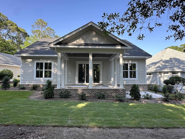 924 Morrall Dr, North Myrtle Beach, SC 29582 - bungalow-style home with covered porch, a front yard, and roof with shingles