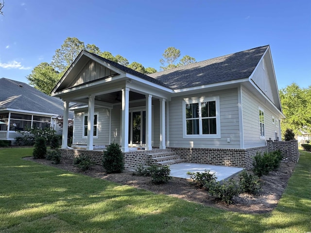 924 Morrall Dr, North Myrtle Beach, SC 29582 - view of front of property featuring a porch, a front lawn, roof with shingles, and board and batten siding