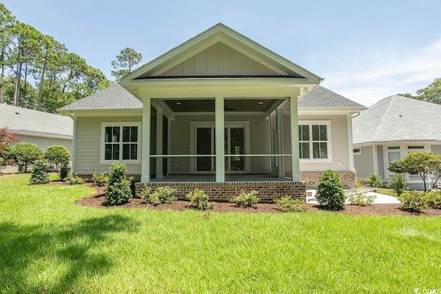 924 Morrall Dr, North Myrtle Beach, SC 29582 - back of house featuring a sunroom, a shingled roof, and a lawn