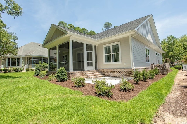 924 Morrall Dr, North Myrtle Beach, SC 29582 - rear view of property featuring a sunroom, a yard, and roof with shingles